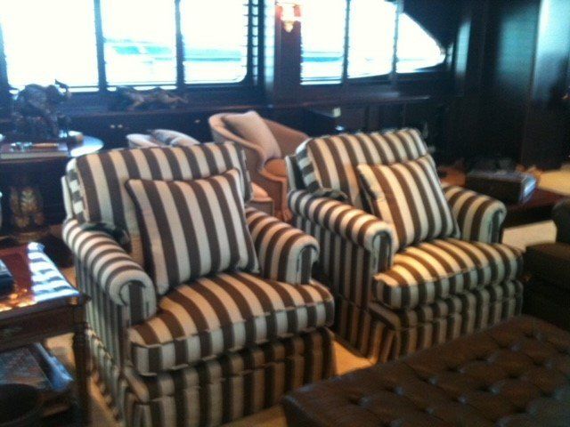 A living room with striped chairs and an ottoman