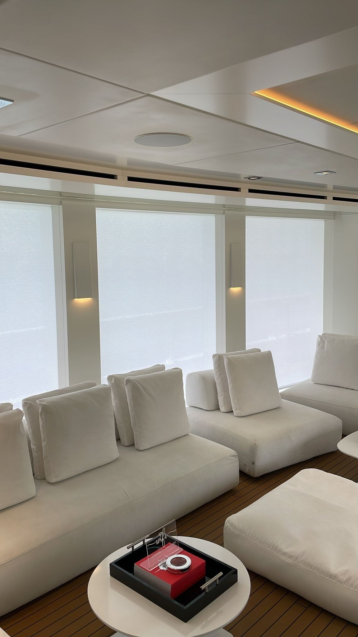 A living room with white furniture and a red box on a table.