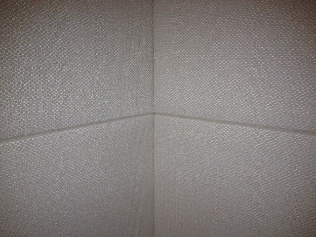 A corner of a room with a white wall.