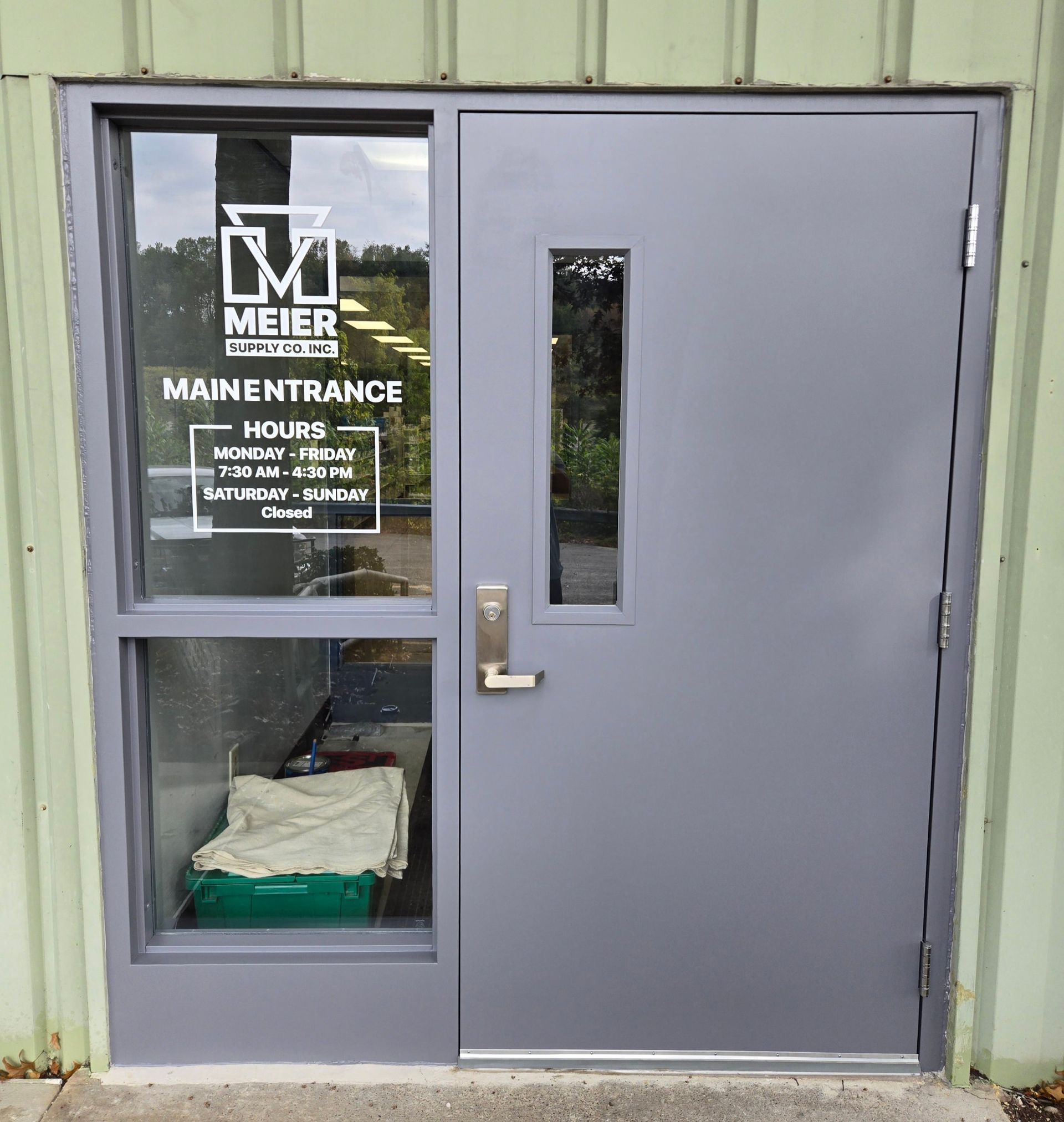 Gray door with a window and a sidelight. 