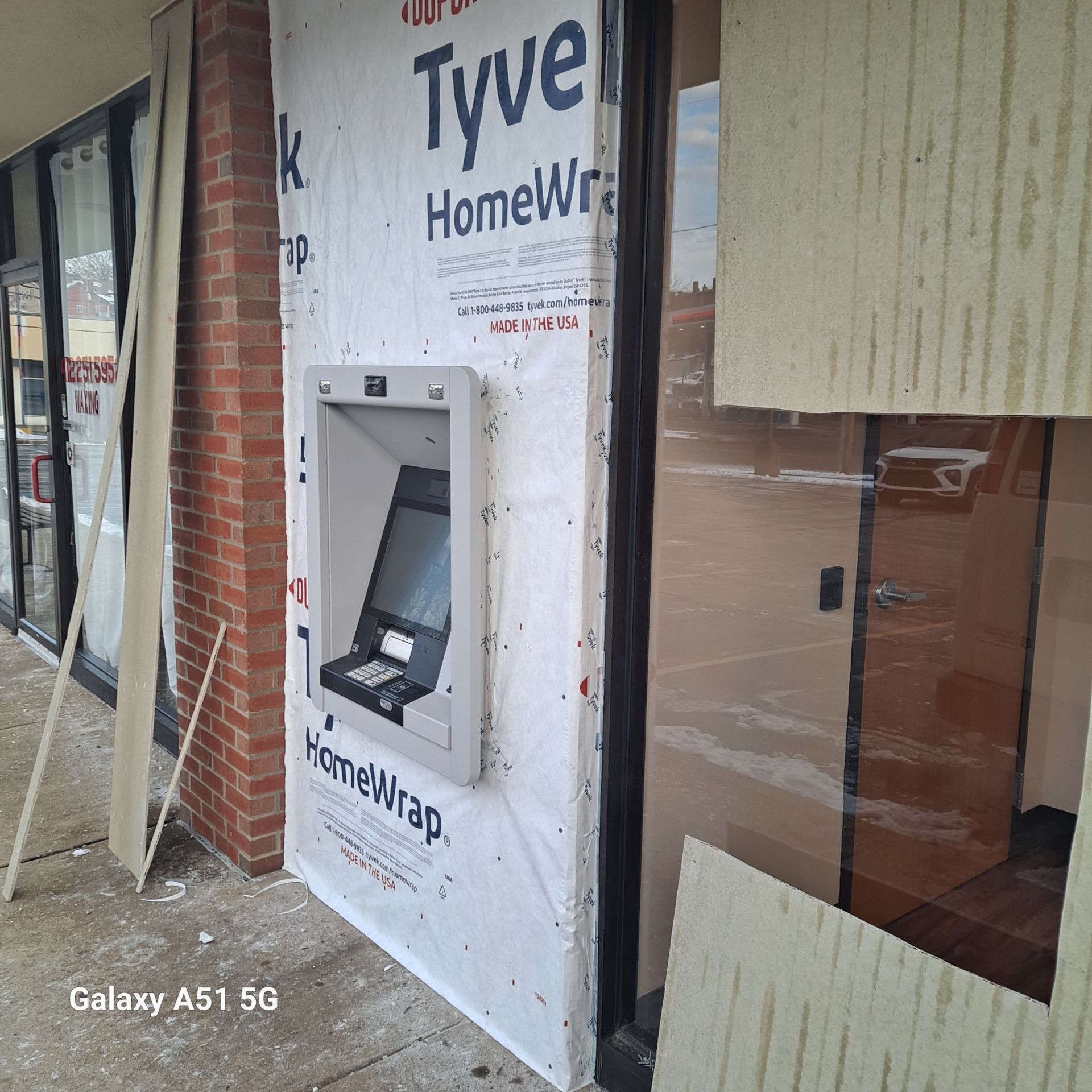 ATM installed in a building undergoing construction; Tyvek HomeWrap visible.