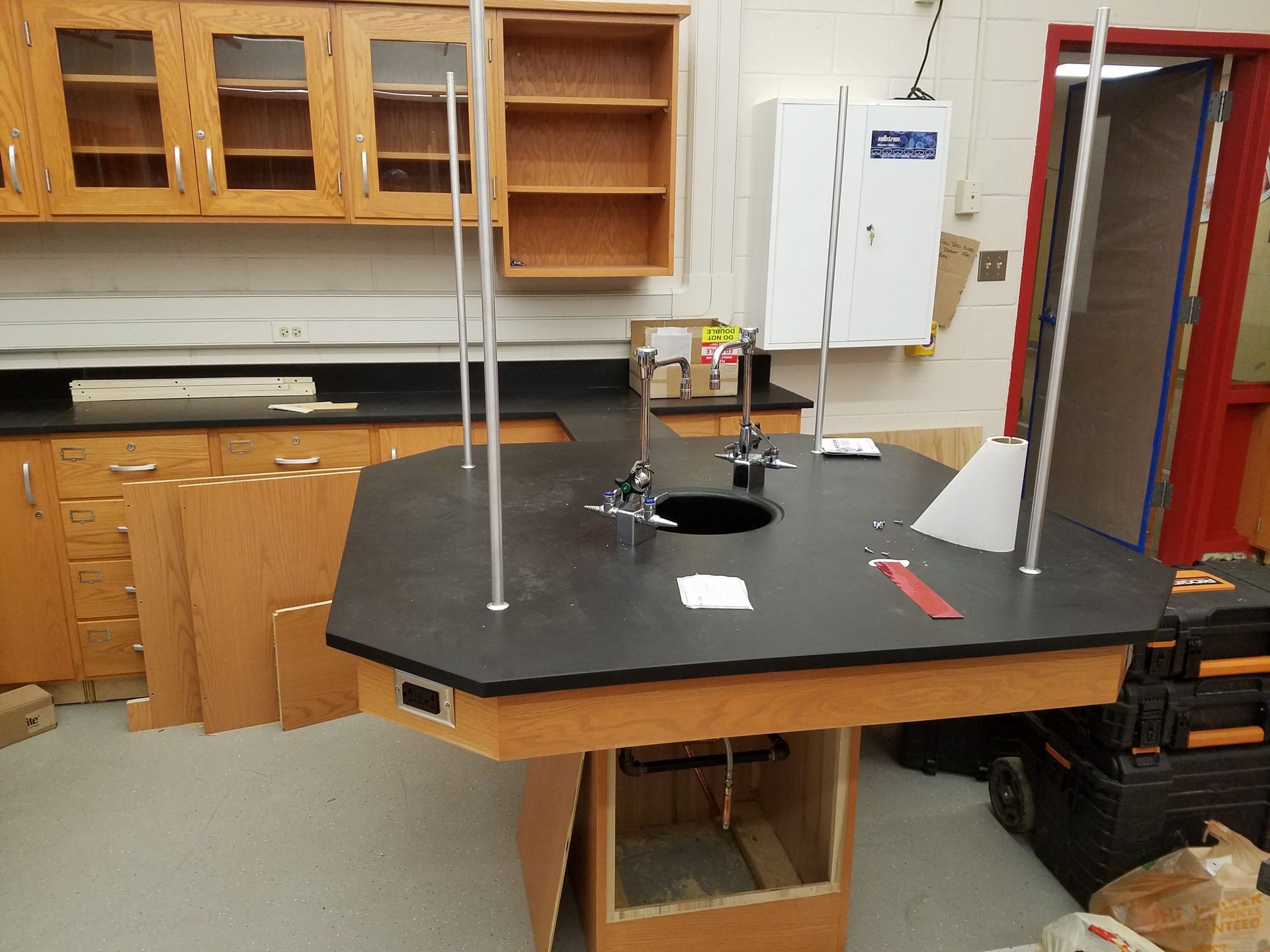 Laboratory table with equipment, cabinets in the background.