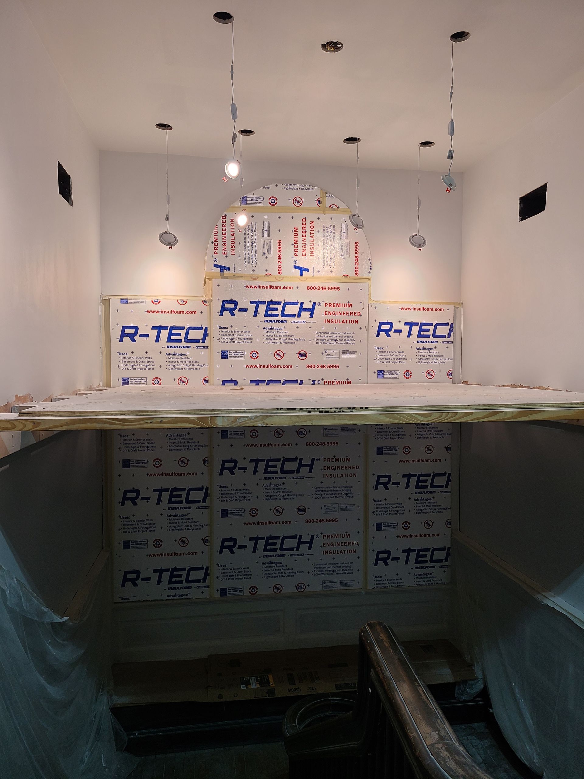 Interior with white walls, R-TECH insulation, and recessed lighting. A section is open, revealing the lower level.