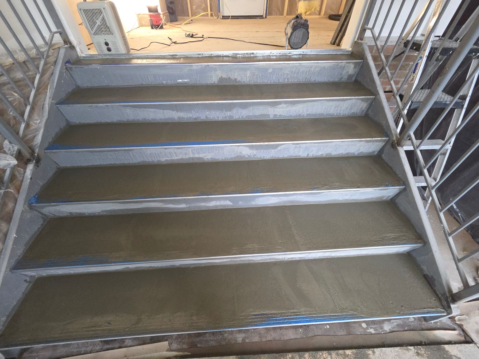 Concrete staircase with metal railings, newly poured concrete steps.