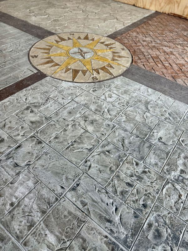 Stamped concrete floor with a compass rose design in the center, surrounded by various textured sections.