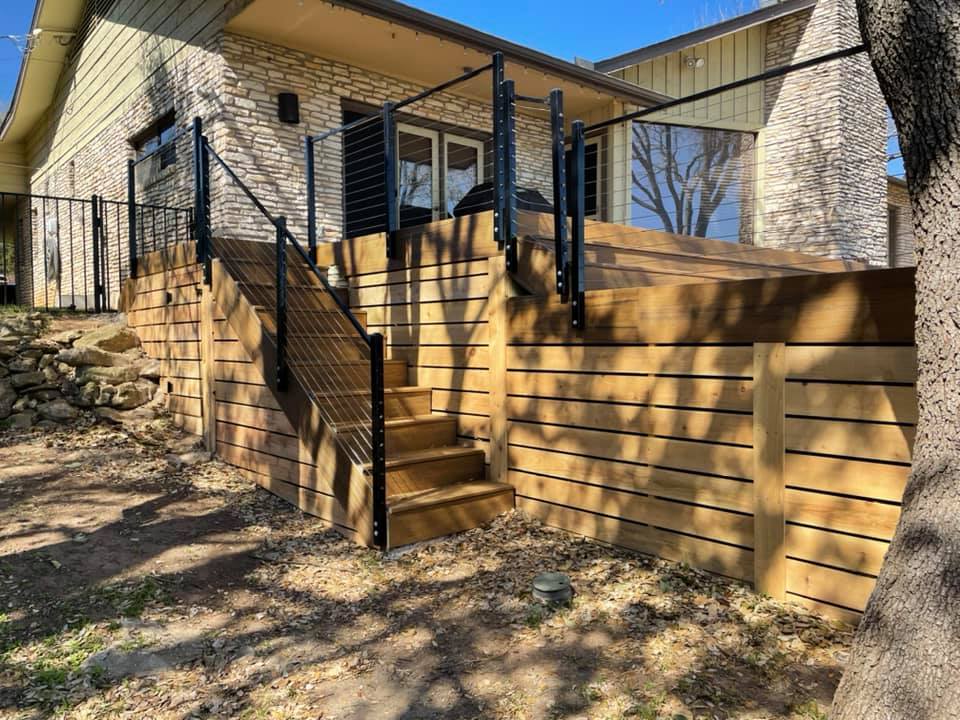 A house with a wooden deck and stairs leading up to it.