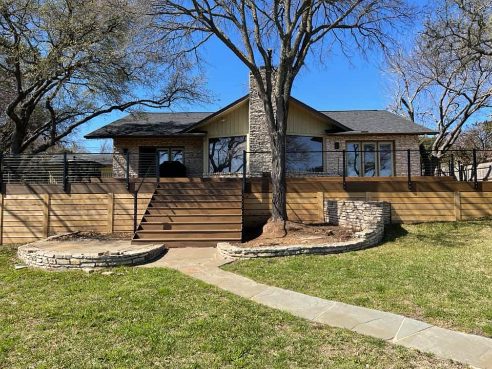A house with a wooden deck and stairs in front of it.