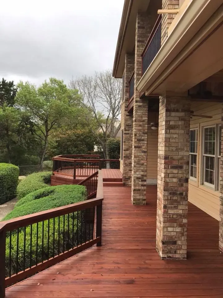 A large house with a wooden deck and brick pillars