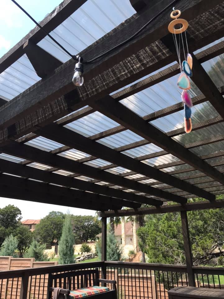 A pergola with a wind chime hanging from the ceiling
