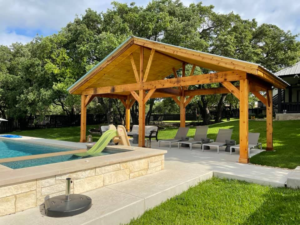 A wooden pavilion is sitting next to a swimming pool.