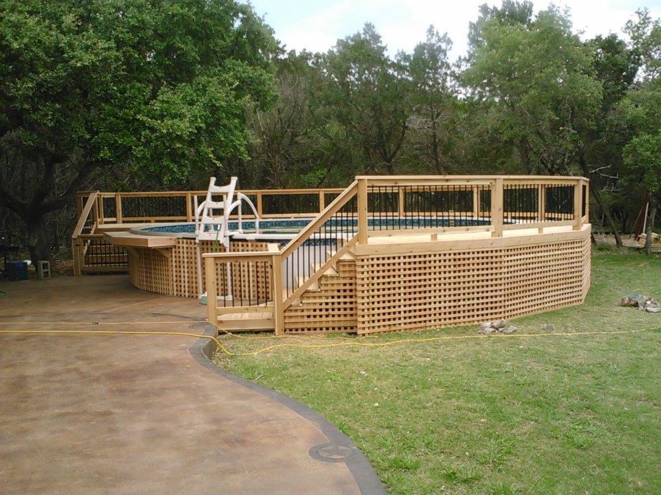 A swimming pool with a wooden deck and stairs