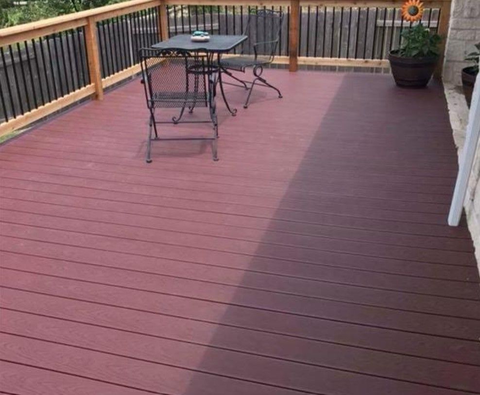 A red deck with a table and chairs on it