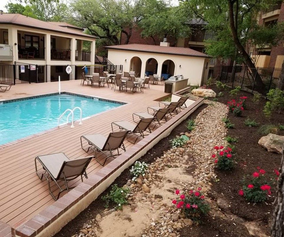 A large swimming pool with a deck and chairs around it