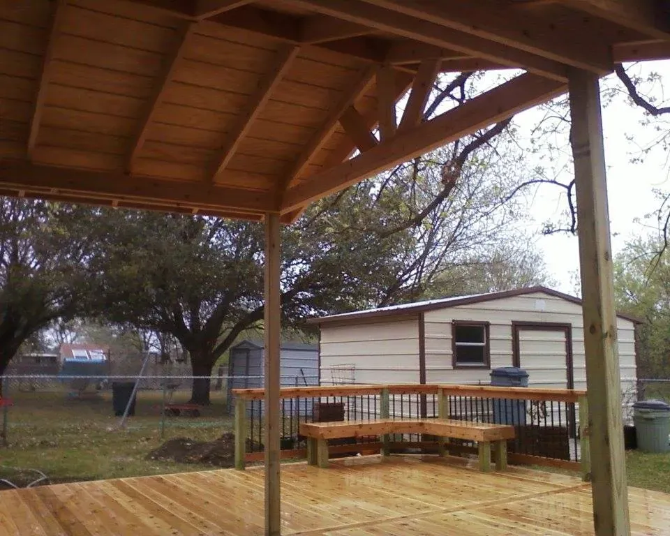 A wooden deck with a shed in the background