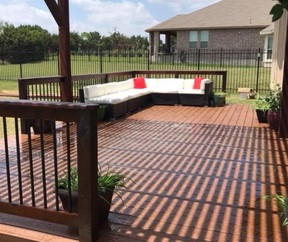 A wooden deck with a sectional couch on it