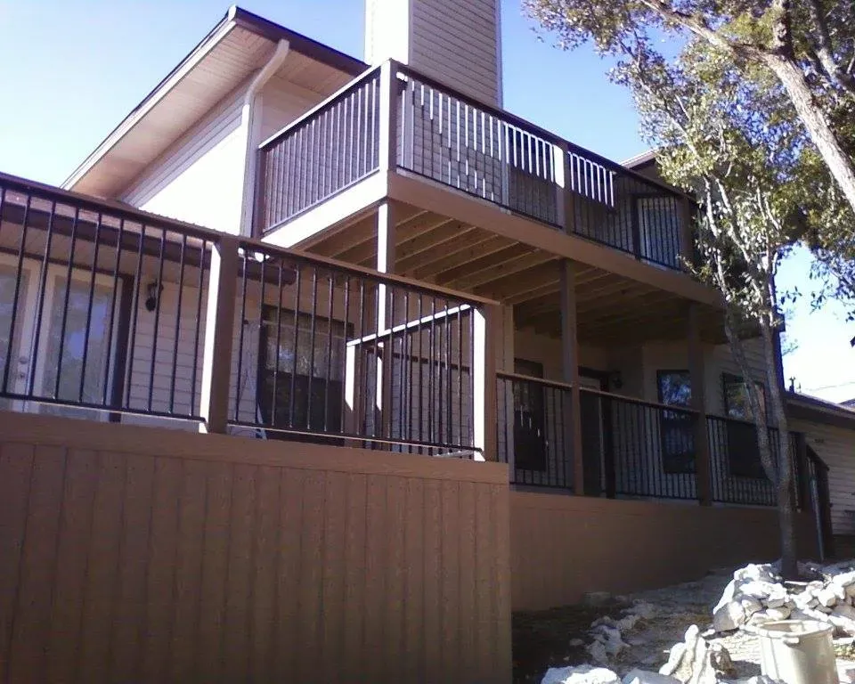 A large house with a large deck and railing