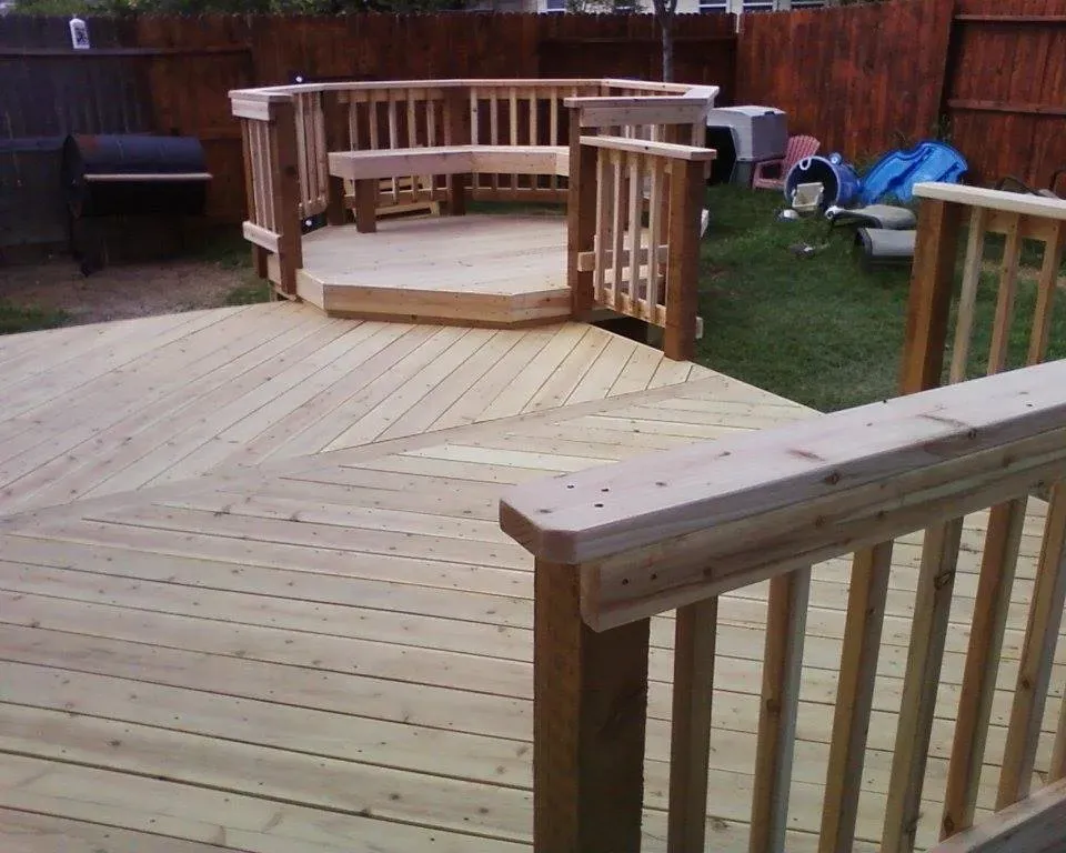 A wooden deck with a bench in the middle of it