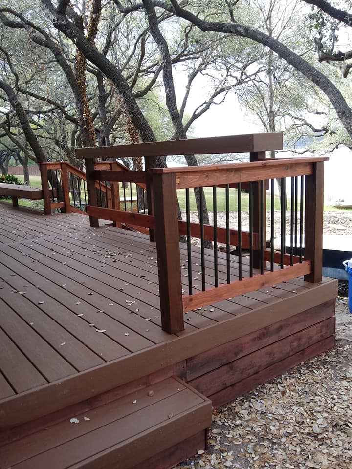 A wooden deck with stairs and trees in the background