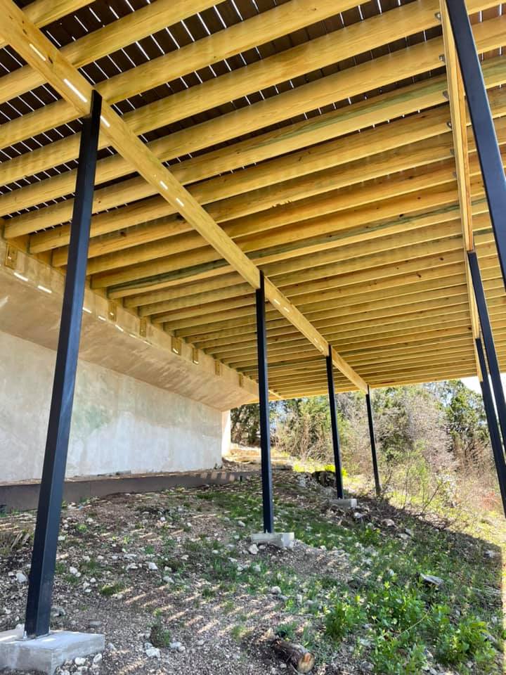 A wooden deck is being built under a bridge.