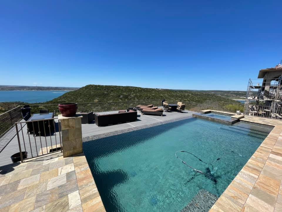 There is a large swimming pool with a view of the ocean.