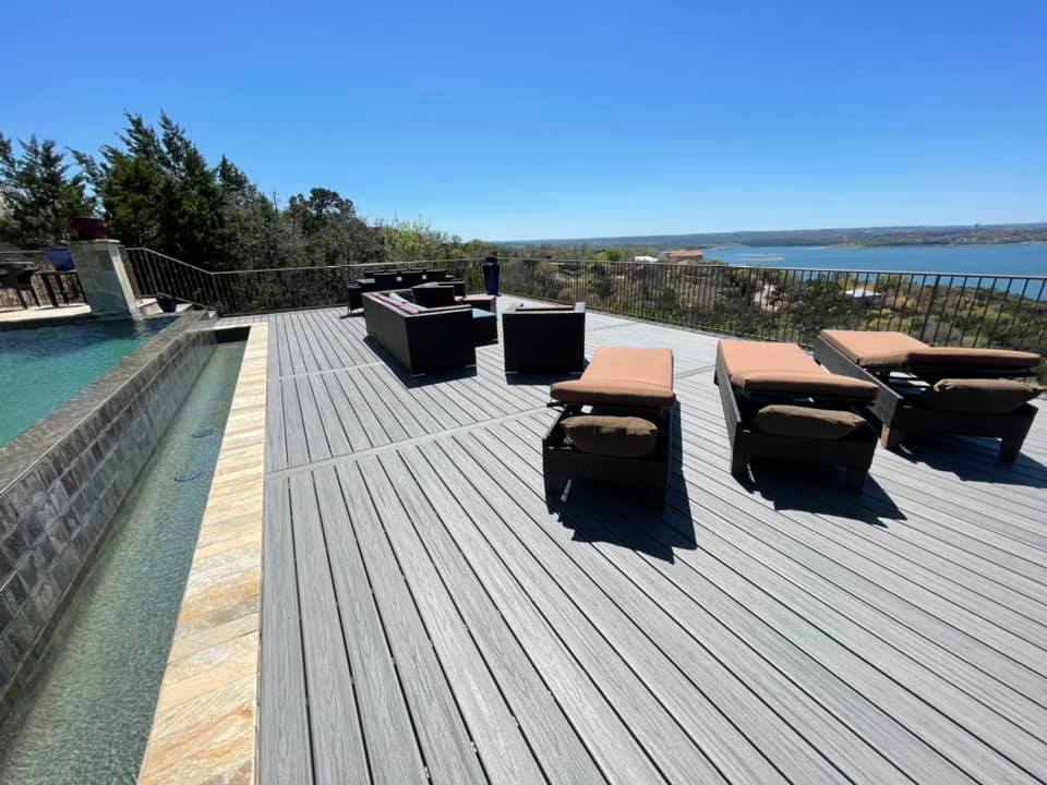 A deck with a view of a lake and a swimming pool