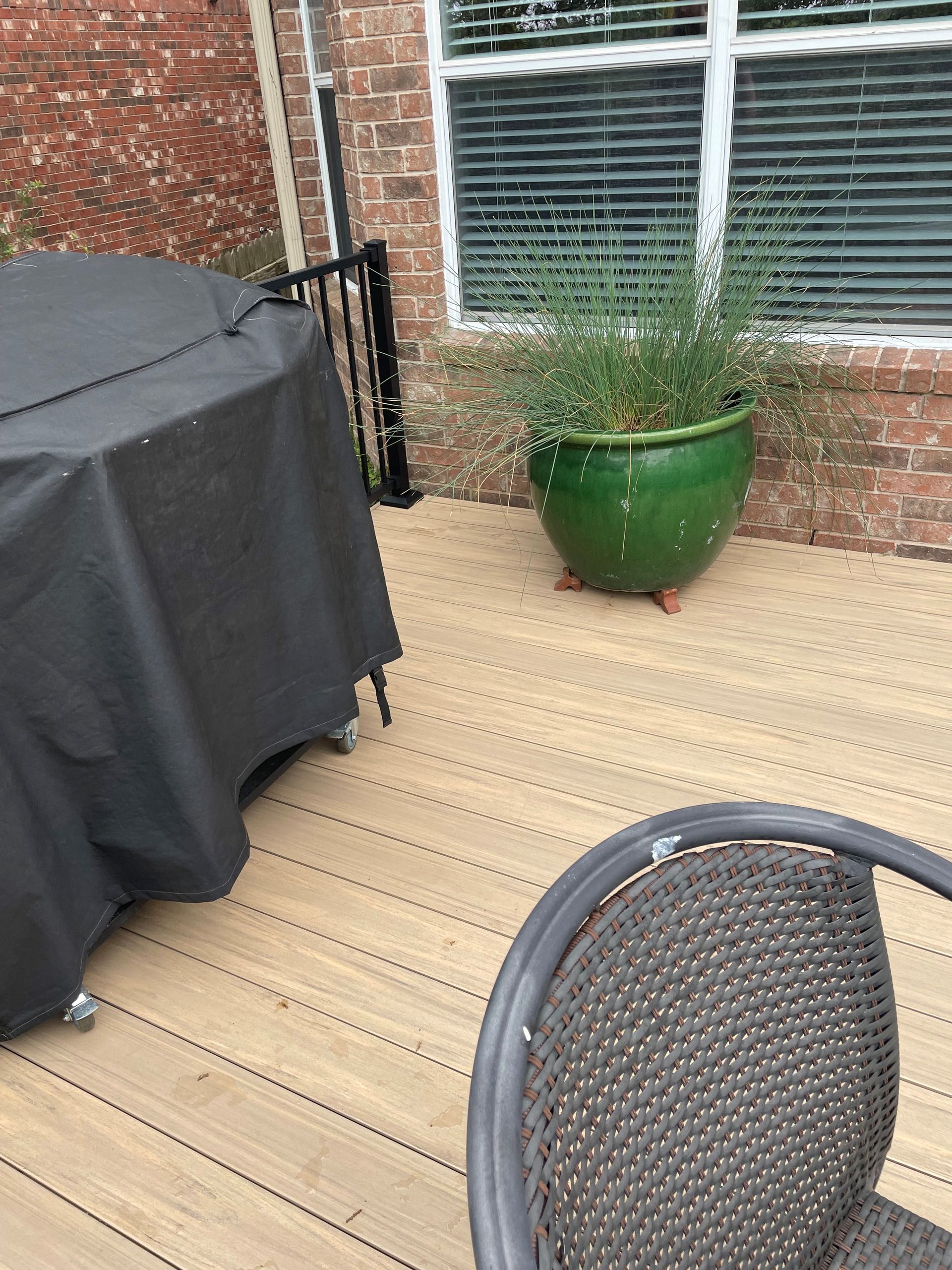 A wooden deck with a chair and a potted plant.