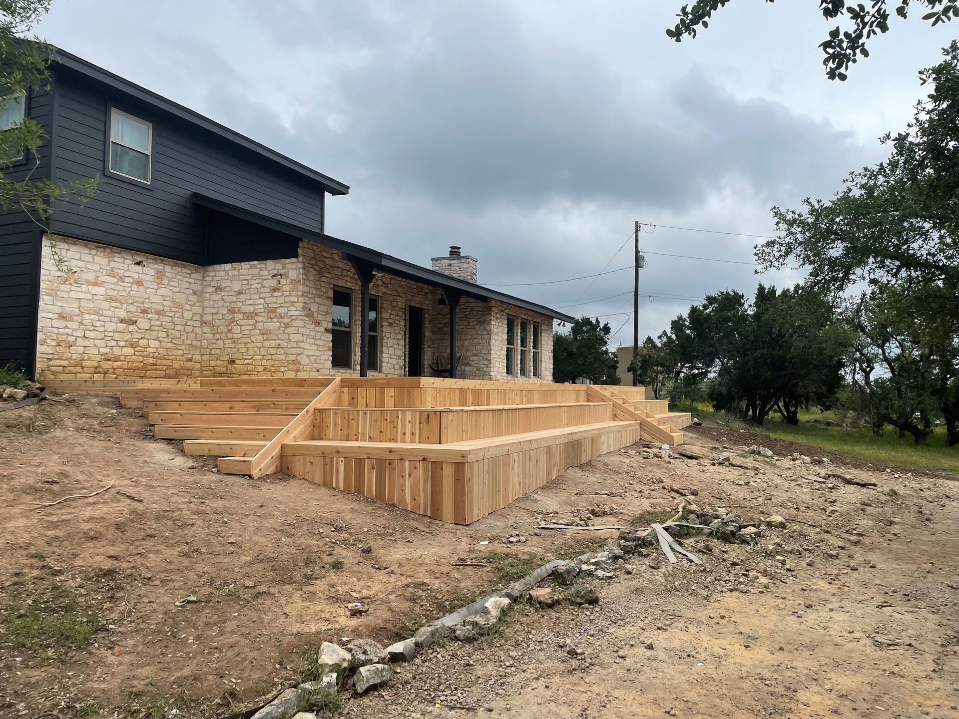 A house with a wooden deck under construction in front of it.