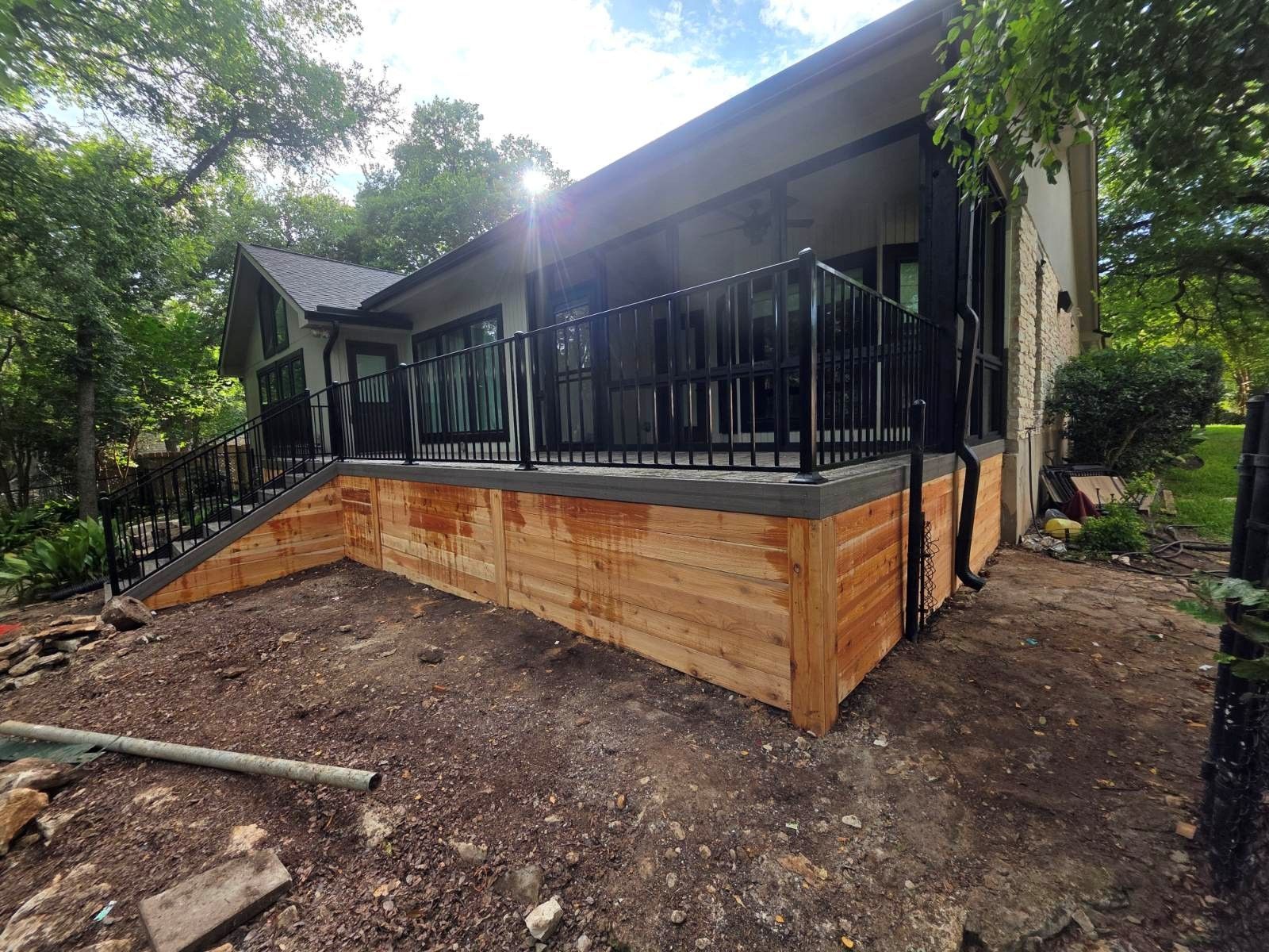 A house with a wooden deck and stairs in front of it.