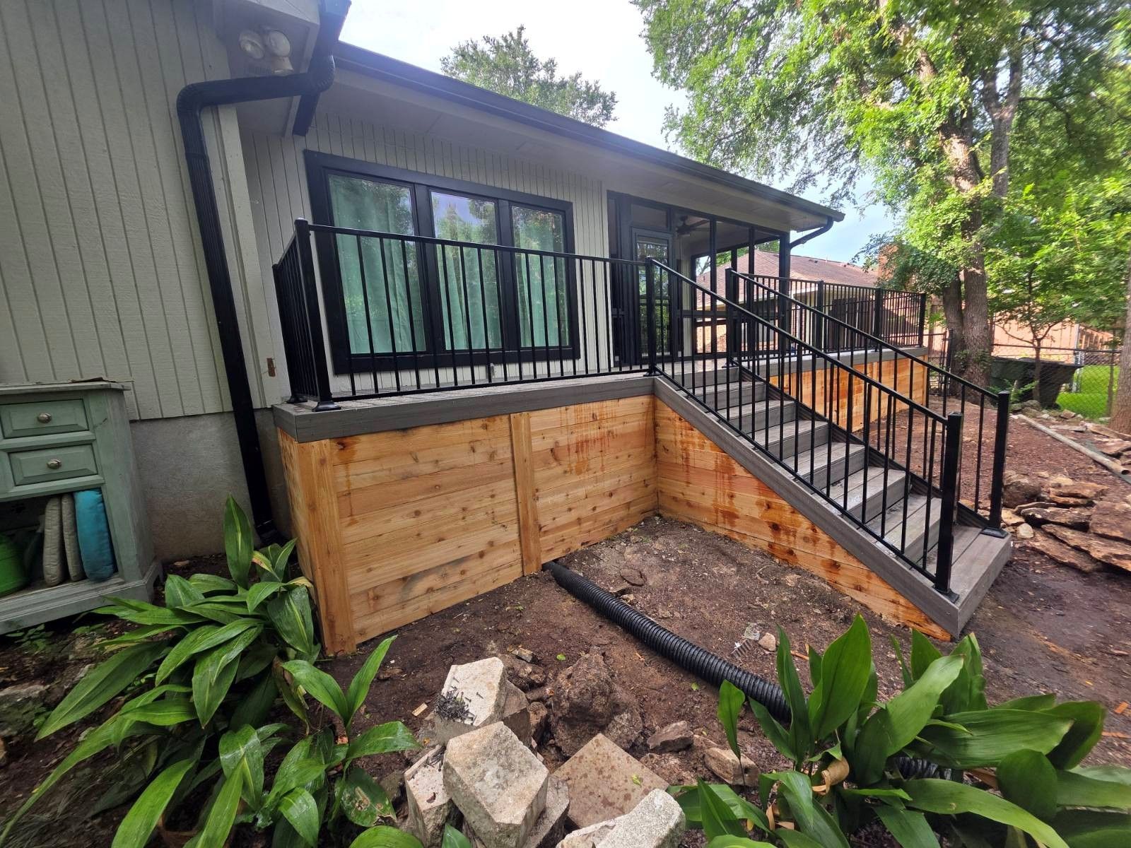 A house with a wooden deck and stairs leading up to it.