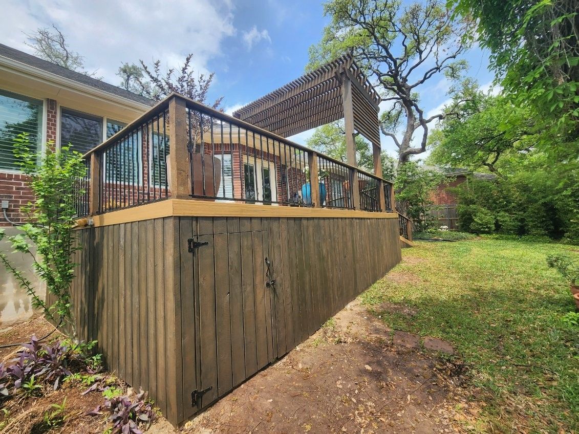 A wooden deck with a pergola on top of it is in the backyard of a house.