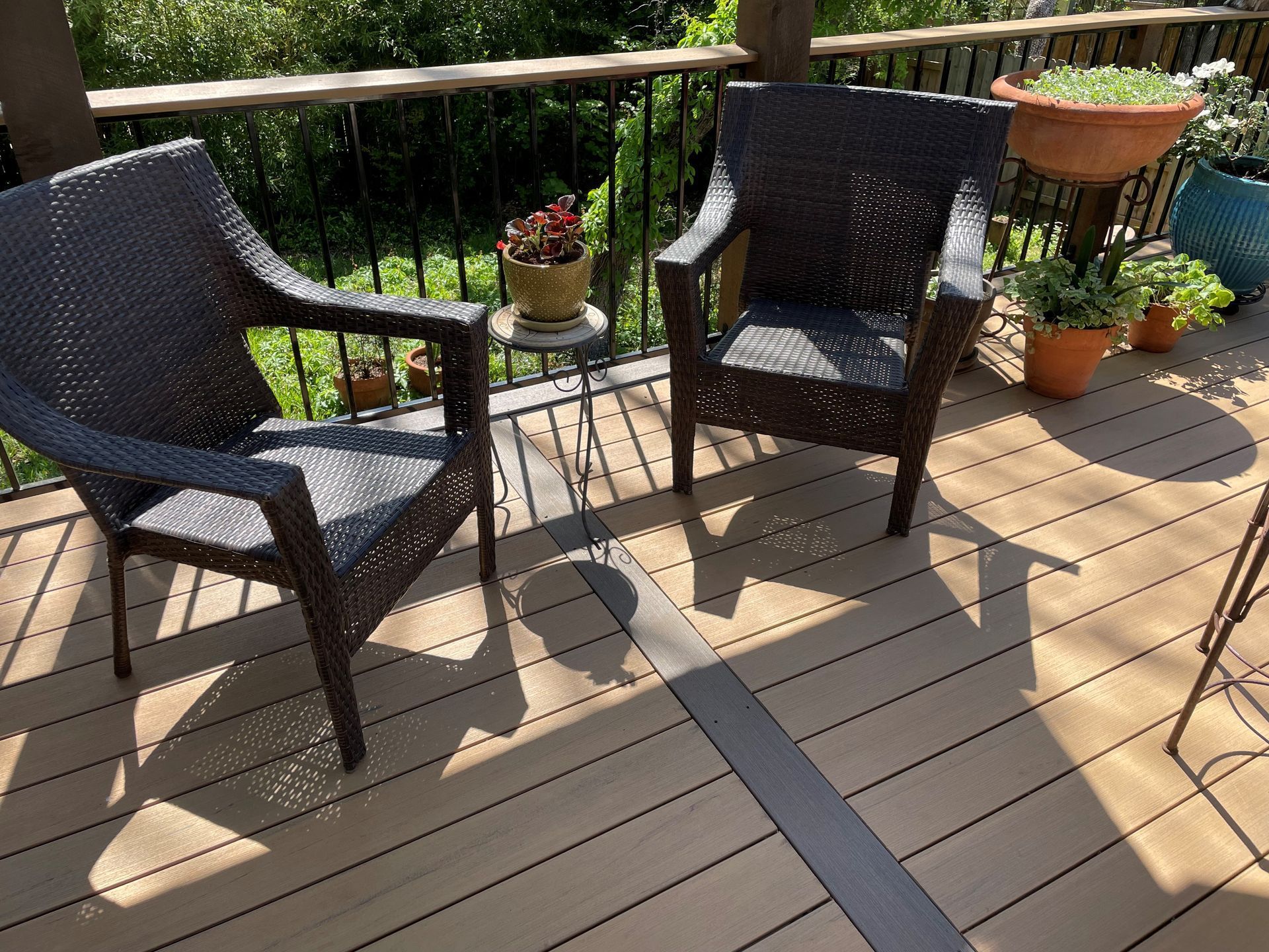 Two wicker chairs are sitting on a wooden deck.