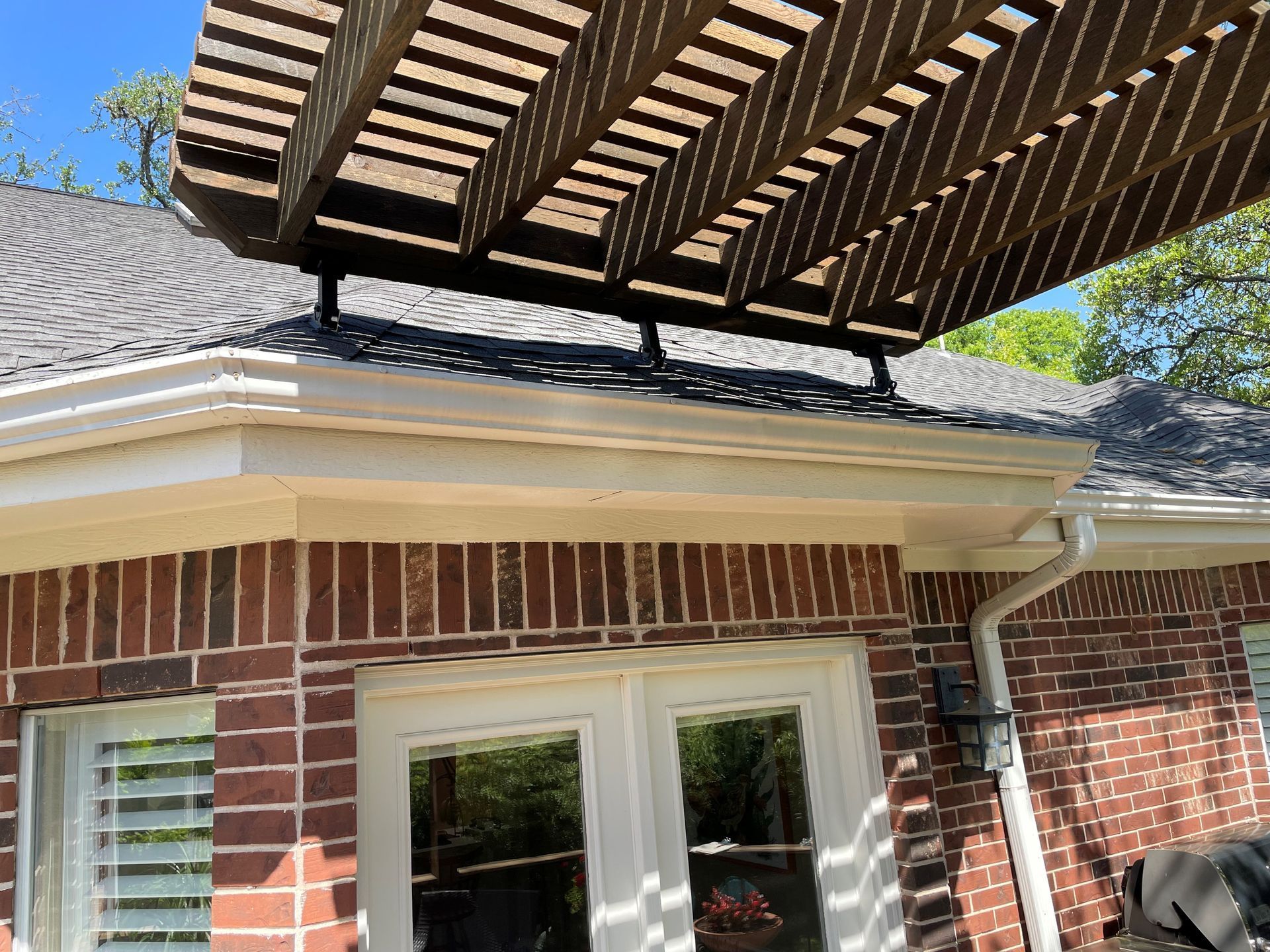A brick house with a pergola on top of it.