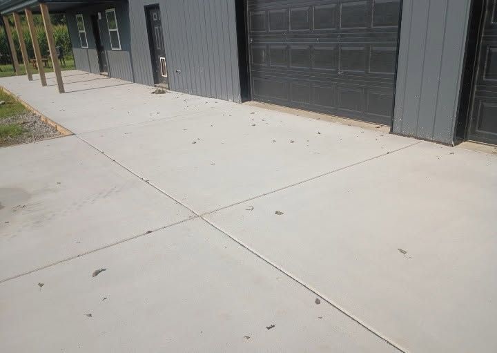 Concrete walkway beside modern gray industrial buildings with garage doors