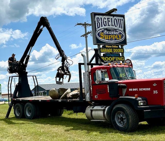 A red truck is parked in front of a biglow sign
