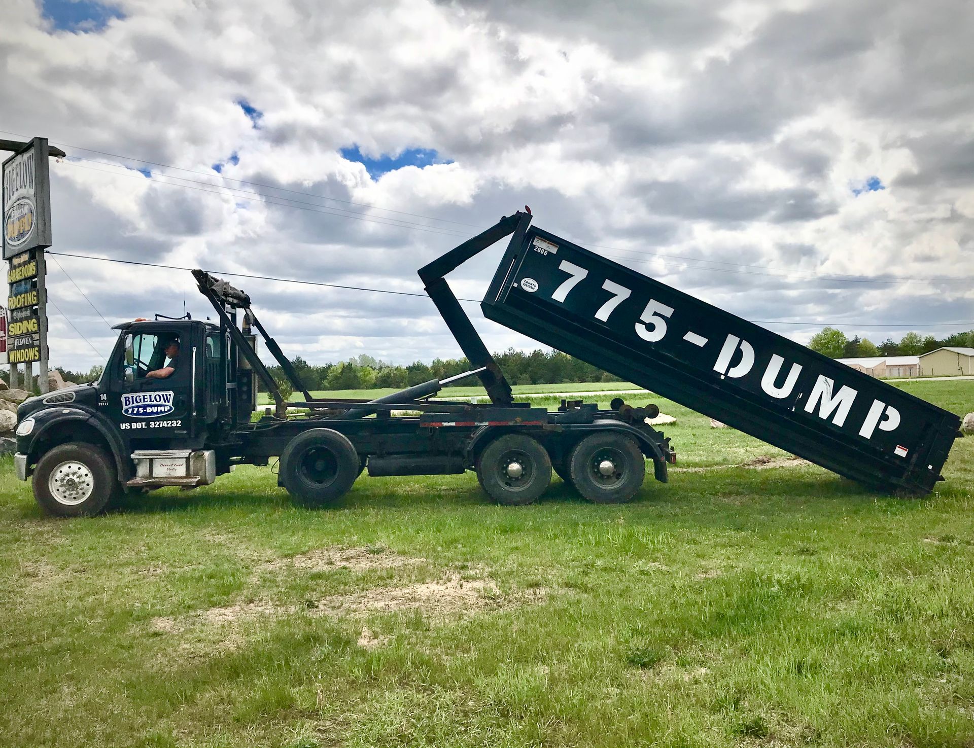 A dump truck is parked in a grassy field