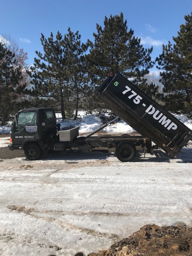 A dump truck is parked in a snowy field