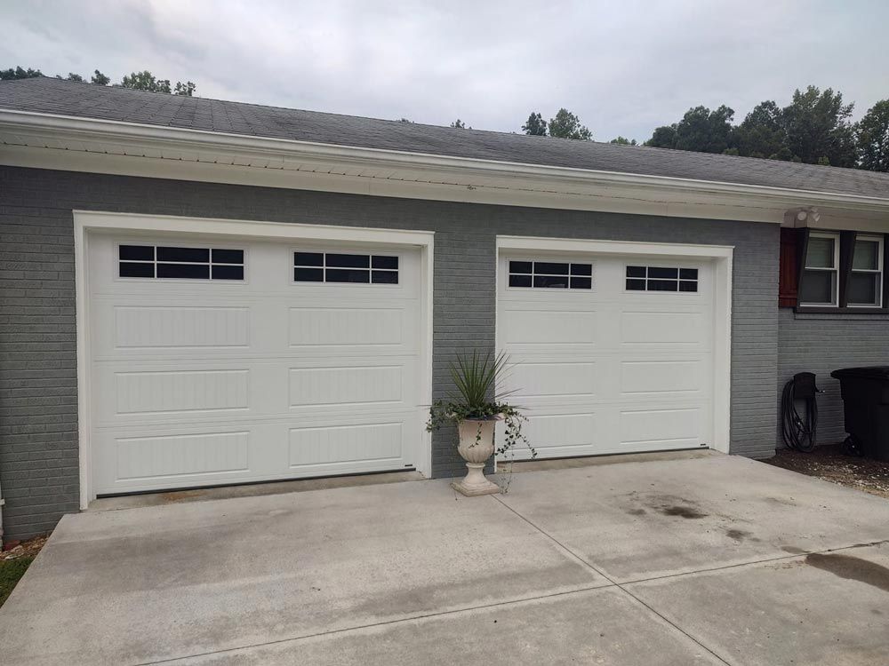 There are two garage doors on the side of a house.