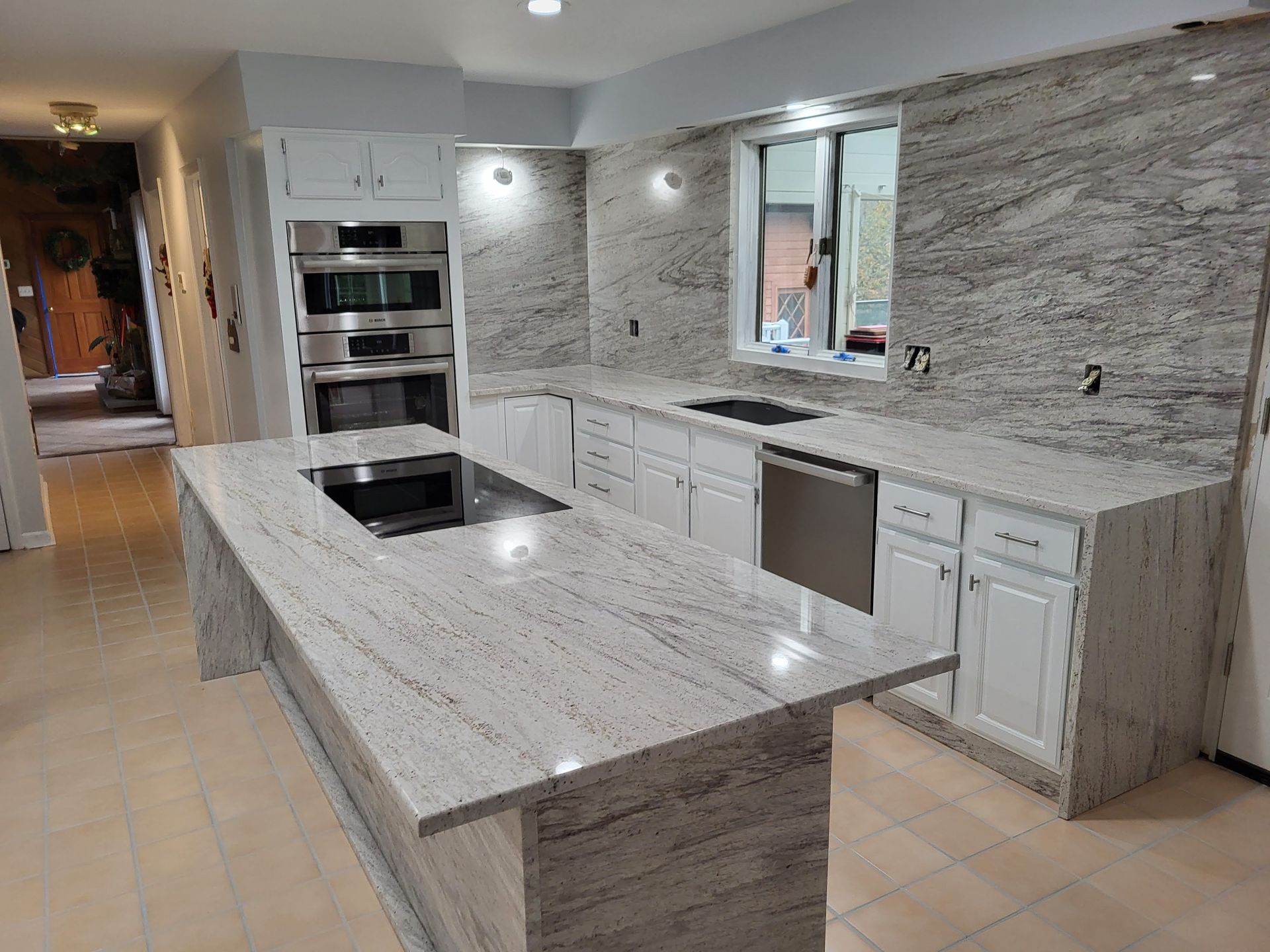 Newly renovated kitchen with white cabinets, granite countertops, and stainless steel appliances.