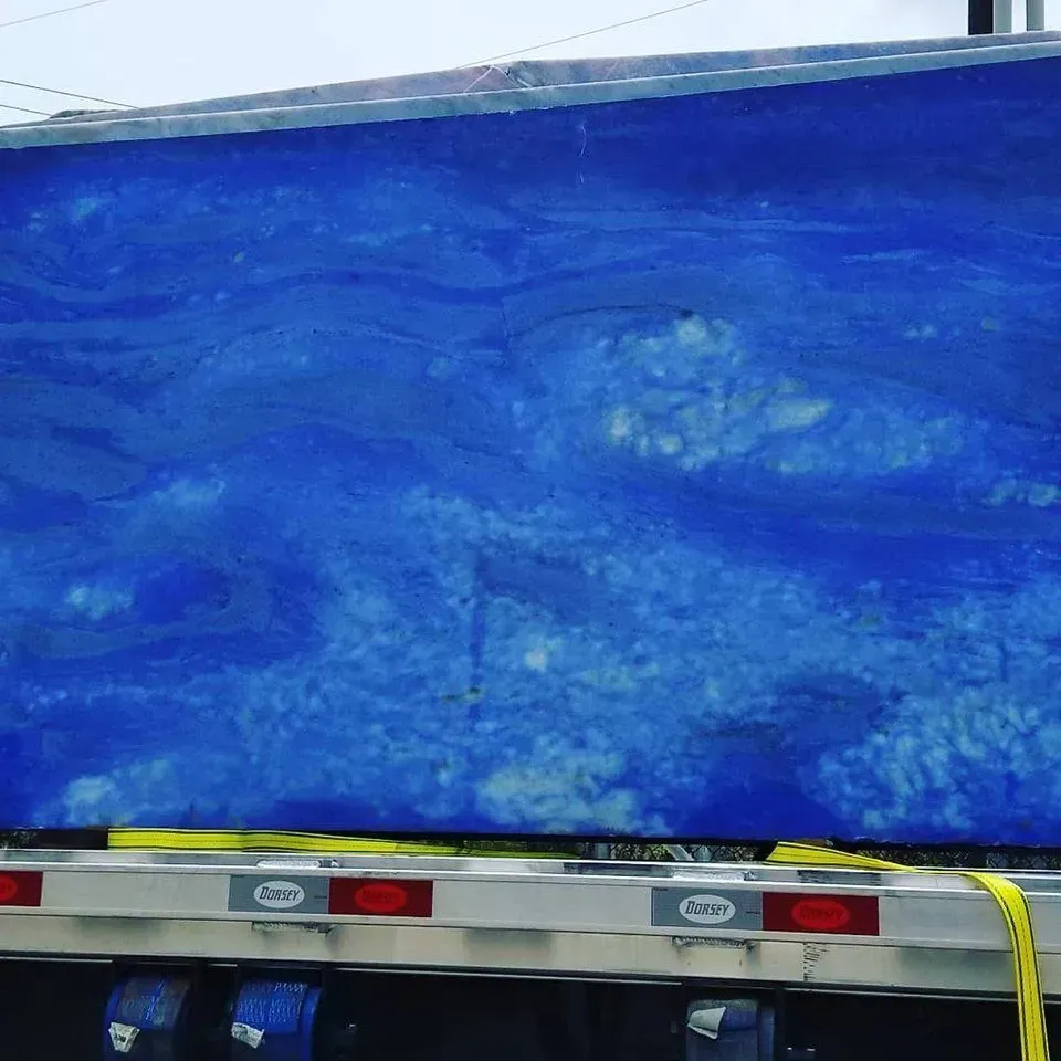 Large blue stone slab on a flatbed truck, likely for construction.