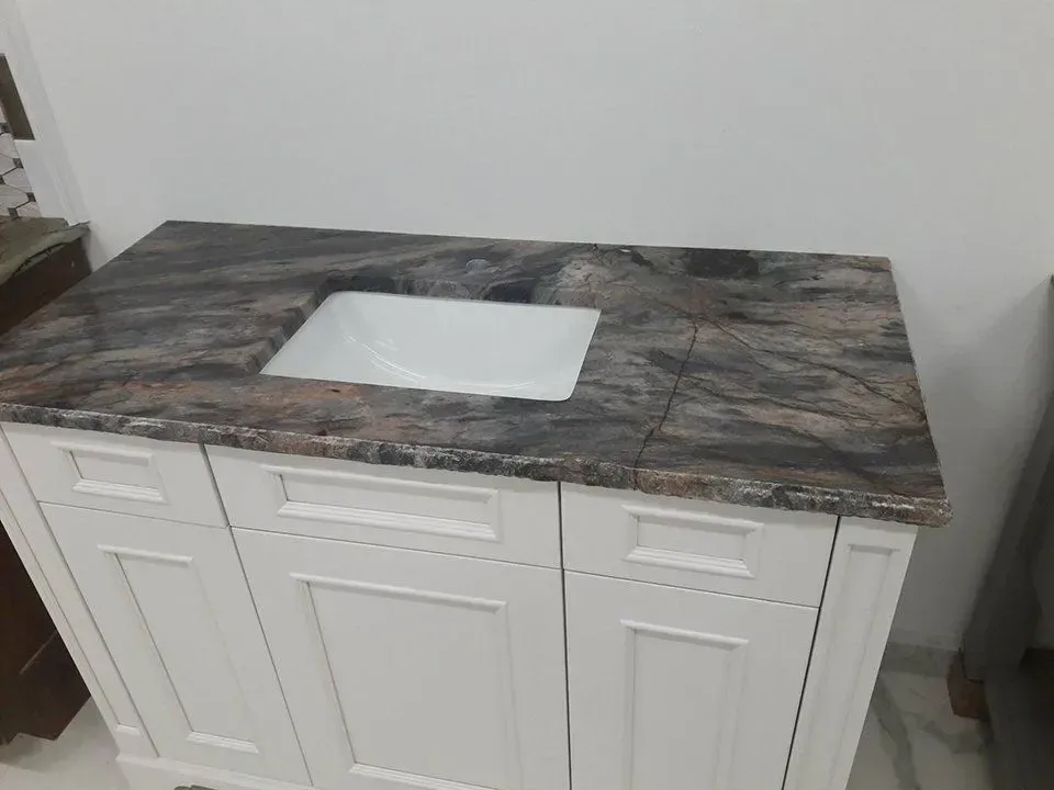 White bathroom vanity with marble countertop and a white sink.