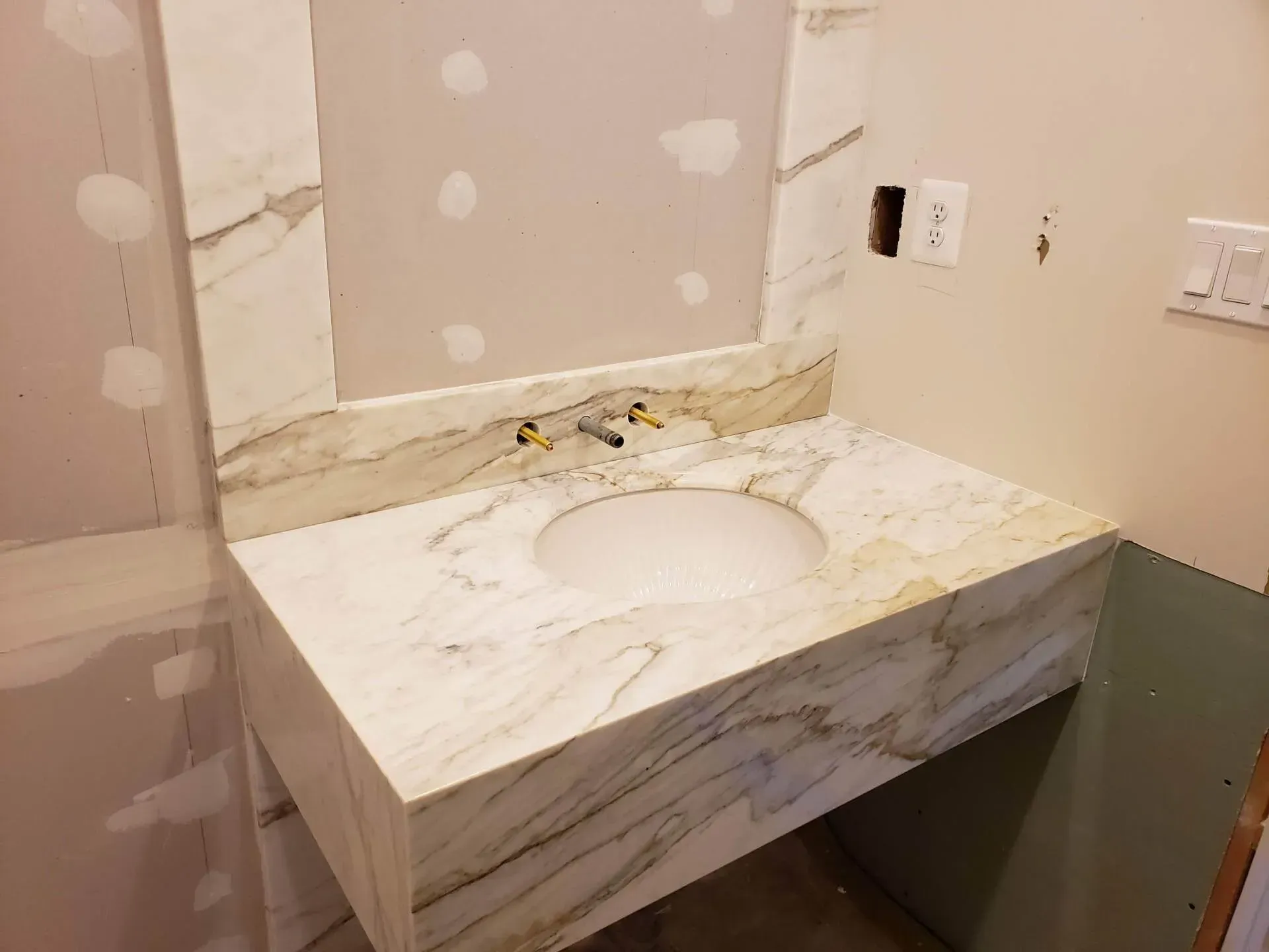 Marble countertop with integrated sink in a bathroom under construction.