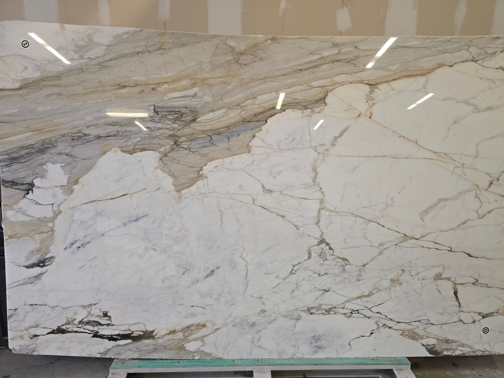 Large slab of white and beige granite with dark veins and swirls.