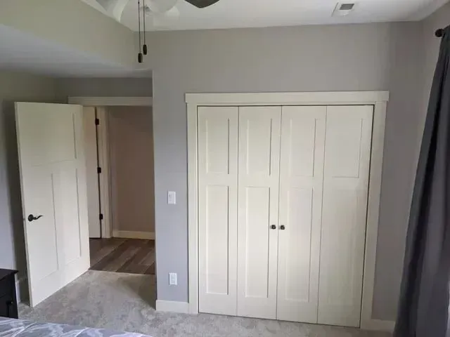 Bedroom with gray walls, white closet and doors, and carpet.