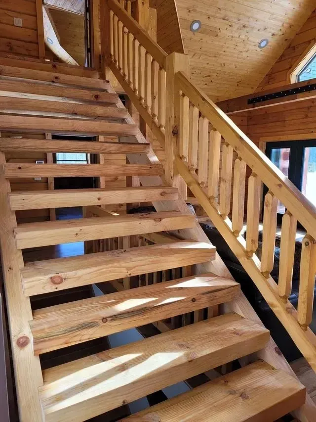 Wooden staircase with railing in a cabin.
