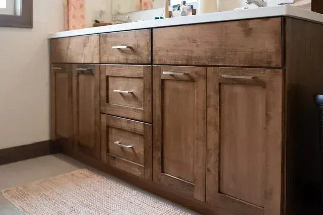 Bathroom vanity with wooden cabinets and a white countertop.