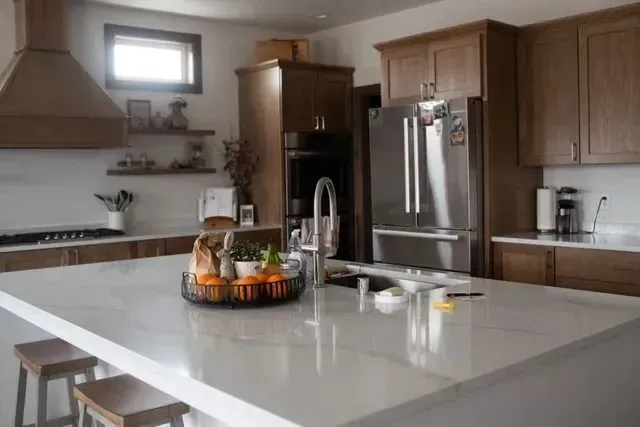Modern kitchen with island, stainless steel appliances, and wooden cabinets.