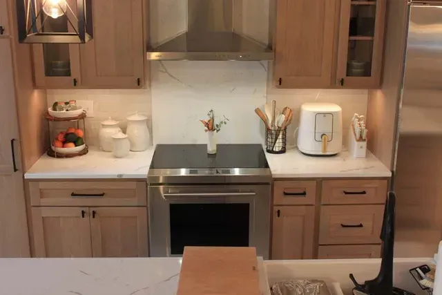 Kitchen with light wood cabinets, stainless steel appliances, and white countertops.