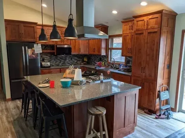 Kitchen with wood cabinets, island, and stainless steel appliances.