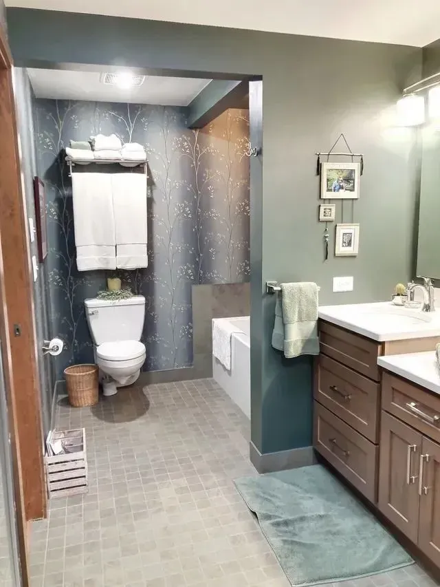 Bathroom with toilet, tub, and vanity; gray and teal color scheme.