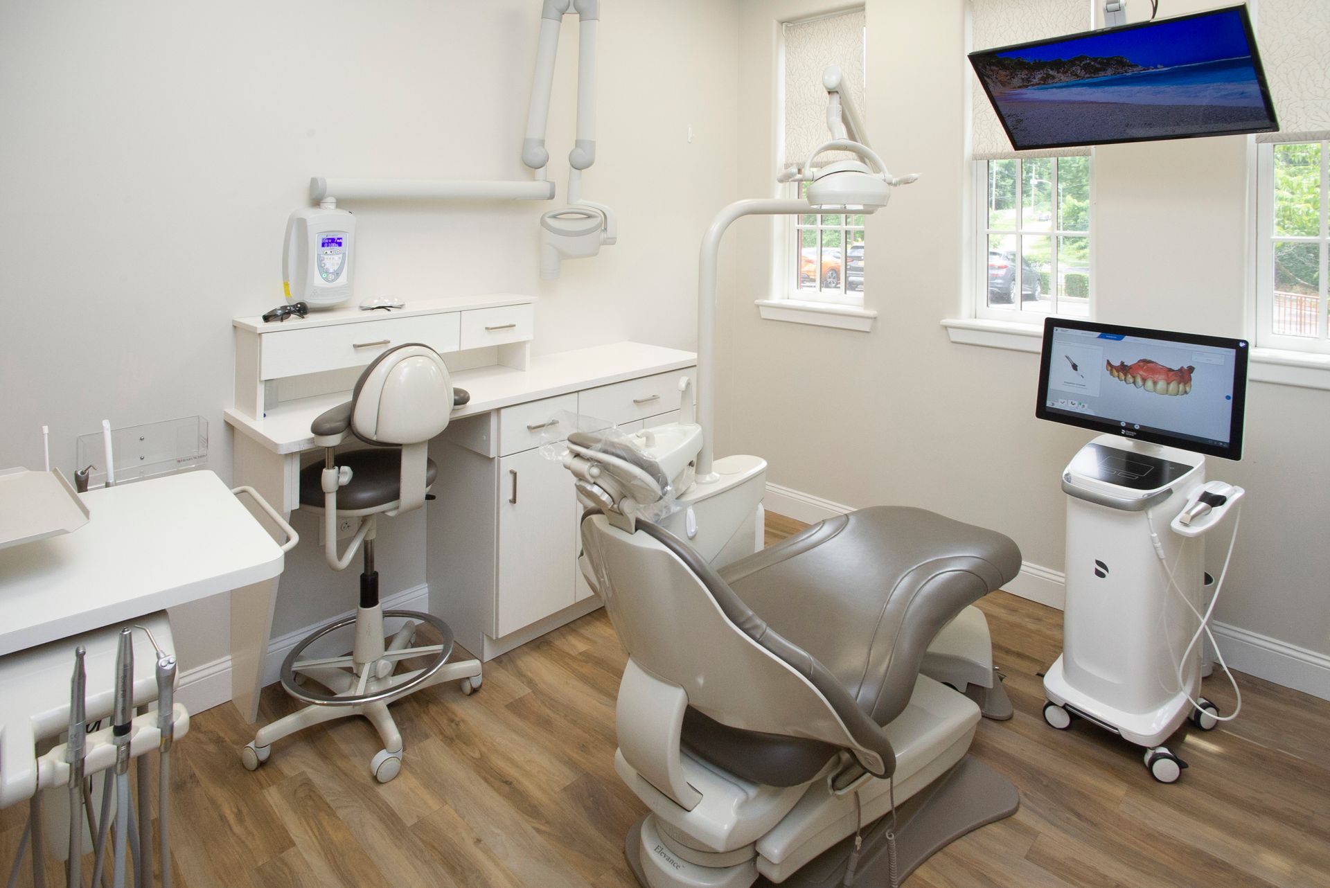A dental office with a dental chair and a computer.